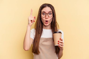 Restoran garsonu kadın elinde sarı arka planda izole edilmiş kahve tutuyor. Harika bir fikri var, yaratıcılık kavramı..