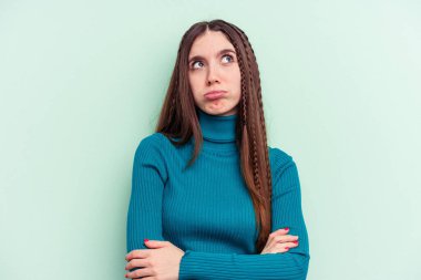 Yeşil arka planda izole edilmiş genç beyaz kadın tekrarlanan bir görevden yoruldu..