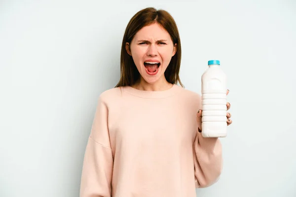 Ung Engelsk Kvinna Håller Flaska Mjölk Isolerad Blå Bakgrund Skriker — Stockfoto