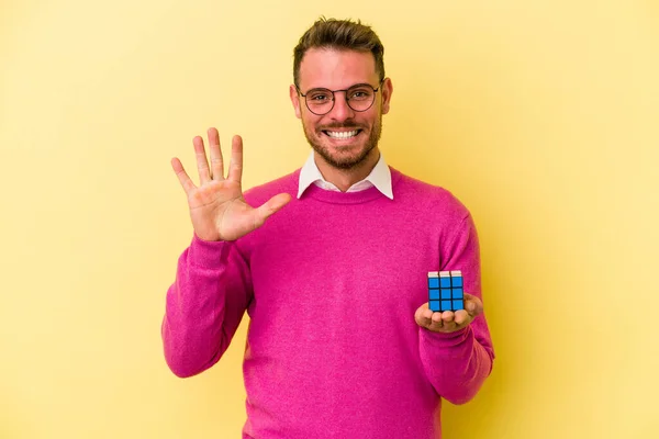 Mladý Kavkazský Muž Drží Rubiks Kostka Izolované Pozadí Veselý Ukazující — Stock fotografie