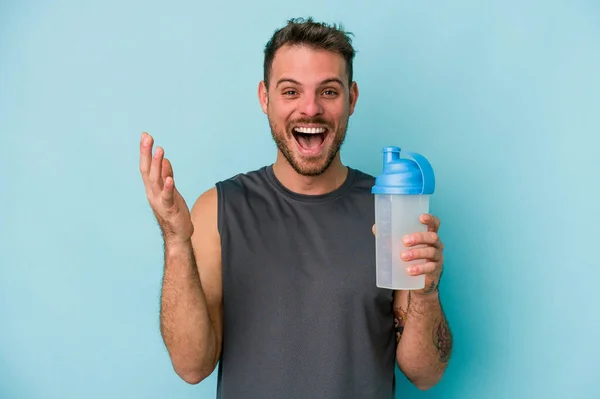 Joven Hombre Caucásico Bebiendo Batido Aislado Sobre Fondo Azul Recibiendo —  Fotos de Stock