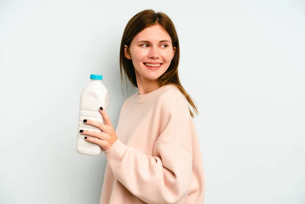 Junge Engländerin Hält Eine Flasche Milch Isoliert Auf Blauem Hintergrund — Stockfoto