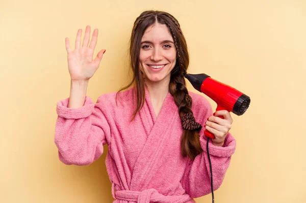 Giovane Donna Che Tiene Asciugacapelli Isolato Sfondo Giallo Sorridente Allegro — Foto Stock