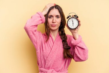 Sarı arka planda izole edilmiş alarm saati tutan beyaz bir kadın şok geçiriyordu. Önemli bir buluşmayı hatırladı..