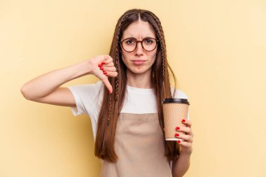 Restoran garsonu elinde kahve tutan kadın sarı arka planda izole edilmiş, hoşlanmadığı bir hareket gösteriyor. Anlaşmazlık konsepti.