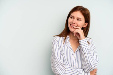 Mavi arka planda izole edilmiş genç bir İngiliz kadın rahatça fotokopi odasına bakan bir şey düşünüyor..
