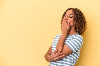 Sarı arka planda izole edilmiş genç Latin transseksüel kadın gülüyor, kaygısız, doğal duygu..