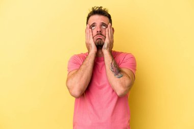 Kafkasyalı genç adam sarı arka planda izole edilmiş sızlanıyor ve ağlıyordu..