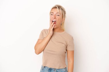 Beyaz arka planda izole edilmiş genç bir Rus kadın esniyor. Ağzı eliyle kapatan yorgun bir hareket sergiliyor..