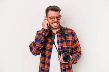 Kafkasyalı genç fotoğrafçı, beyaz arka planda izole edilmiş kulakları elleriyle kapatıyor..