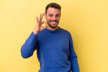 Genç beyaz adam sarı arka planda izole edilmiş neşeli ve kendinden emin..