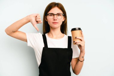 Restoran garsonu elinde kahve tutan kadın mavi arka planda izole edilmiş, hoşlanmadığı bir hareket gösteriyor. Anlaşmazlık konsepti.