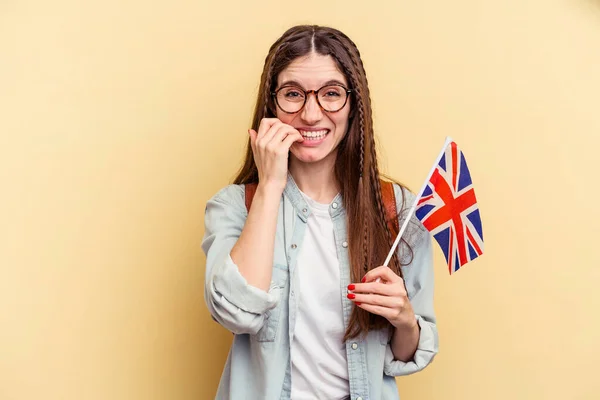 Jovem Caucasiana Estudando Inglês Isolado Fundo Amarelo Mordendo Unhas Nervoso — Fotografia de Stock