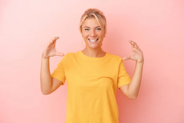 Ung Rysk Kvinna Isolerad Rosa Bakgrund Håller Något Med Handflator — Stockfoto