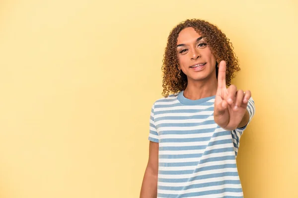 若いラテン語の性転換女性は指でナンバーワンを示す黄色の背景に隔離 — ストック写真