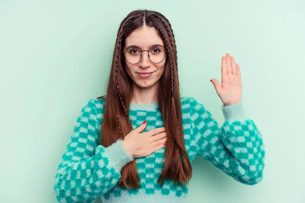 Young Caucasian Woman Isolated Green Background Taking Oath Putting Hand — Φωτογραφία Αρχείου