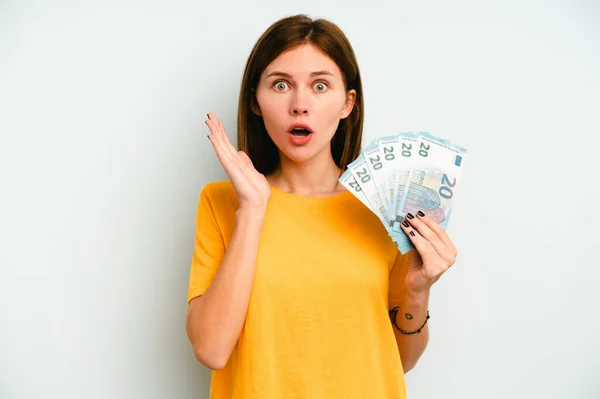 Joven Mujer Inglesa Sosteniendo Billetes Aislados Sobre Fondo Azul Sorprendida — Foto de Stock