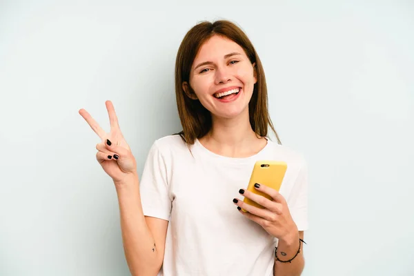 Ung Engelsk Kvinna Som Håller Mobiltelefon Isolerad Blå Bakgrund Glad — Stockfoto
