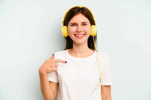 Jovem Inglesa Ouvindo Música Isolada Fundo Azul Pessoa Apontando Mão — Fotografia de Stock