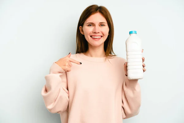 Junge Engländerin Hält Eine Flasche Milch Isoliert Auf Blauem Hintergrund — Stockfoto