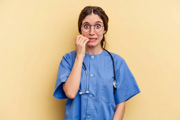 Jovem Enfermeira Caucasiana Isolada Fundo Amarelo Mordendo Unhas Nervosa Muito — Fotografia de Stock
