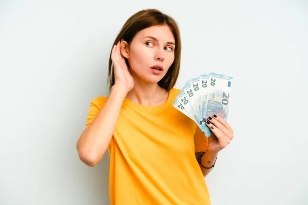 Jovem Inglesa Segurando Notas Isoladas Fundo Azul Tentando Ouvir Uma — Fotografia de Stock