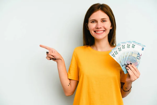 Young English Woman Holding Banknotes Isolated Blue Background Smiling Pointing — Stock Photo, Image