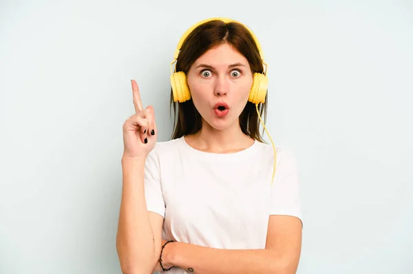 Jovem Inglesa Ouvindo Música Isolada Fundo Azul Tendo Alguma Grande — Fotografia de Stock