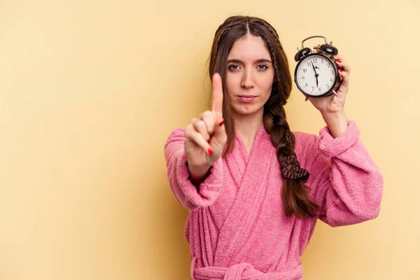 Young Caucasian Woman Wearing Bathrobe Holding Alarm Clock Isolated Yellow — Stock Photo, Image