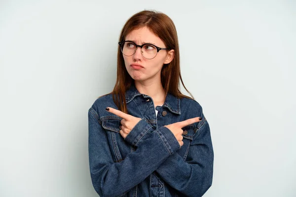 Jonge Engelse Vrouw Geïsoleerd Blauwe Achtergrond Punten Zijwaarts Probeert Kiezen — Stockfoto