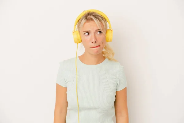 Jovem Russa Ouvindo Música Isolada Fundo Branco Confuso Sente Duvidosa — Fotografia de Stock