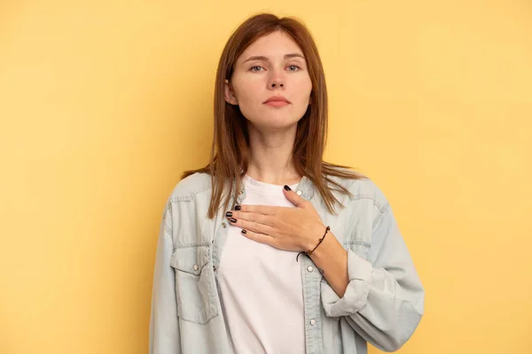 Mladá Angličanka Izolovaná Žlutém Pozadí Skládající Přísahu Pokládající Ruku Hruď — Stock fotografie