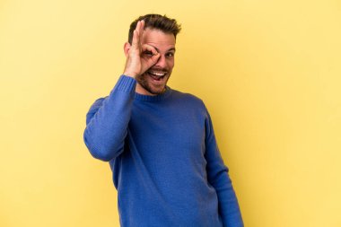 Kafkasyalı genç adam sarı arka planda izole edilmiş. Heyecanlı..