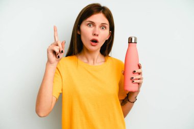 Mavi arka planda izole edilmiş bir termo tutan genç İngiliz kadının bir fikri, ilham konsepti var..