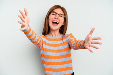 Mavi arka planda izole edilmiş genç İngiliz kadın kameraya sarıldığı için kendinden emin hissediyor..