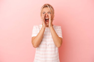 Pembe arka planda izole edilmiş genç bir Rus kadın heyecanla bağırıyor..