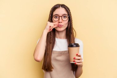 Restoran garsonu elinde kahve tutan kadın sarı arka planda izole edilmiş dudaklarında parmakları olan bir sır saklıyor..