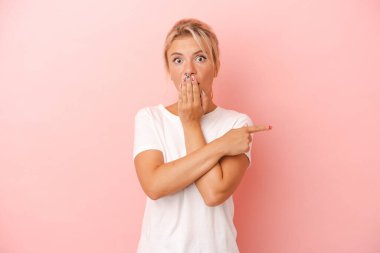 Pembe arka planda izole edilmiş genç Rus kadın yan tarafı gösteriyor.