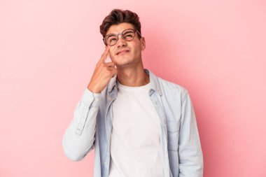 Kafkasyalı genç bir adam pembe arka planda izole edilmiş ağlıyordu, bir şeyden mutsuzdu, acı ve kafa karışıklığı içeriyordu..