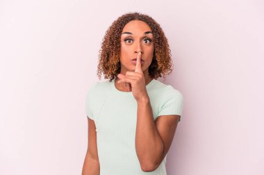 Pembe arka planda izole edilmiş genç Latin transseksüel kadın ya sır saklıyor ya da sessizlik istiyor..