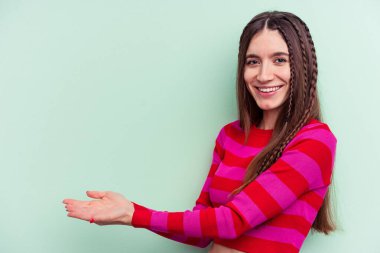 Yeşil arka planda izole edilmiş beyaz bir kadın. Elinde palmiye ağacında bir kopya alanı var..