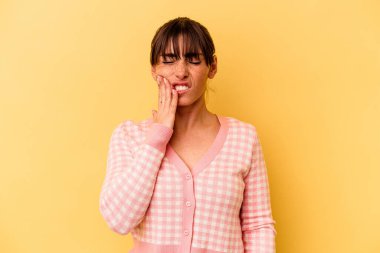 Sarı arka planda izole edilmiş genç Arjantinli kadın güçlü bir diş ağrısı, azıdişi ağrısı var..