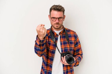 Beyaz arka planda izole edilmiş genç beyaz fotoğrafçı yumruğunu kameraya gösteriyor, agresif yüz ifadesi..