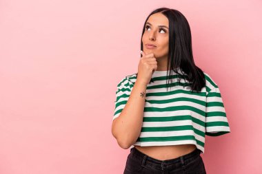 Pembe arka planda tek kollu beyaz bir kadın şüpheli ve şüpheci bir ifadeyle yana bakıyor..