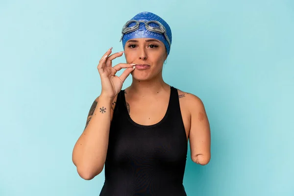 年轻的游泳者 白人女子 一只手被蓝色背景隔开 手指放在嘴唇上保守秘密 — 图库照片
