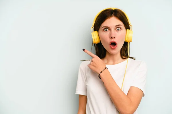 Jeune Femme Anglaise Écoutant Musique Isolée Sur Fond Bleu Pointant — Photo