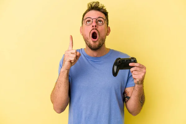 Young Caucasian Man Holding Game Controller Isolated Yellow Background Pointing — Stock Photo, Image