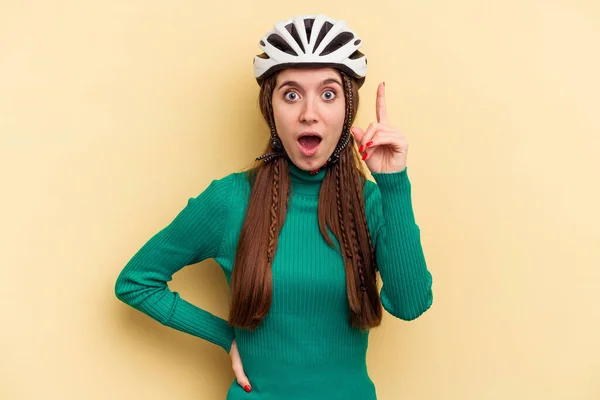 年轻的高加索女人 戴着一顶黄色背景隔离的头盔自行车 有一个想法 灵感的概念 — 图库照片
