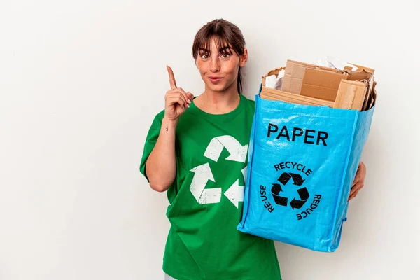 若いアルゼンチンの女性は 指でナンバーワンを示す黄色の背景に隔離された紙をリサイクル — ストック写真