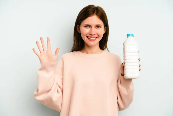 Ung Engelsk Kvinna Håller Flaska Mjölk Isolerad Blå Bakgrund Ler — Stockfoto